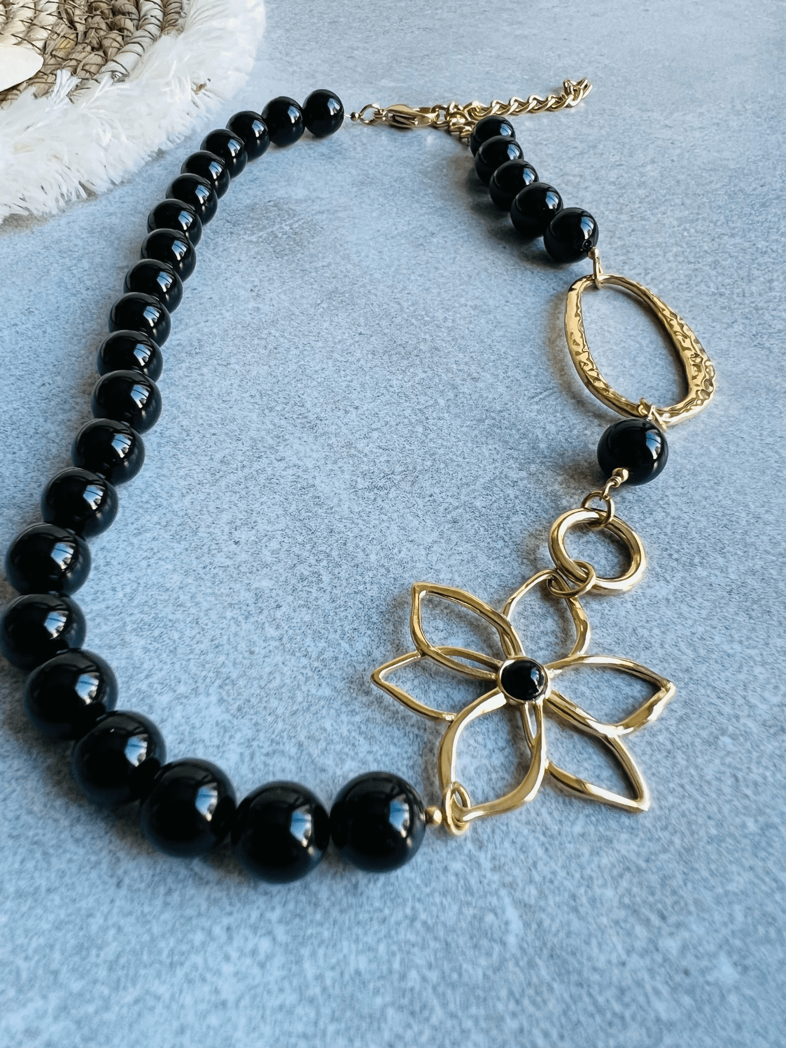 Collier asymétrique MARYLENE perles noires et fleur dorée - Créations Uniques
